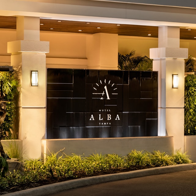 Black acrylic water wall with illuminated "ALBA" logo at Hotel Alba entrance in Tampa, Florida, enhancing aesthetic appeal and branding for commercial spaces.