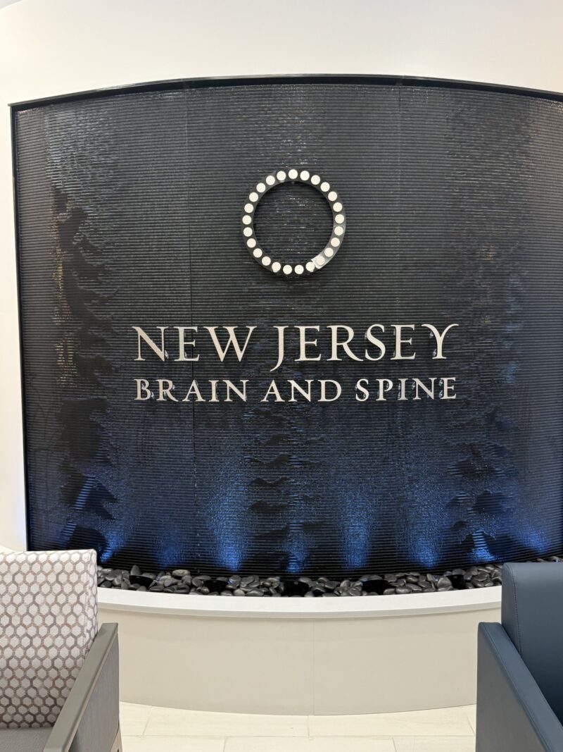 Curved Black Scored Acrylic Aquafall Water Wall with Logo for New Jersey Brain and Spine in Paramus, NJ