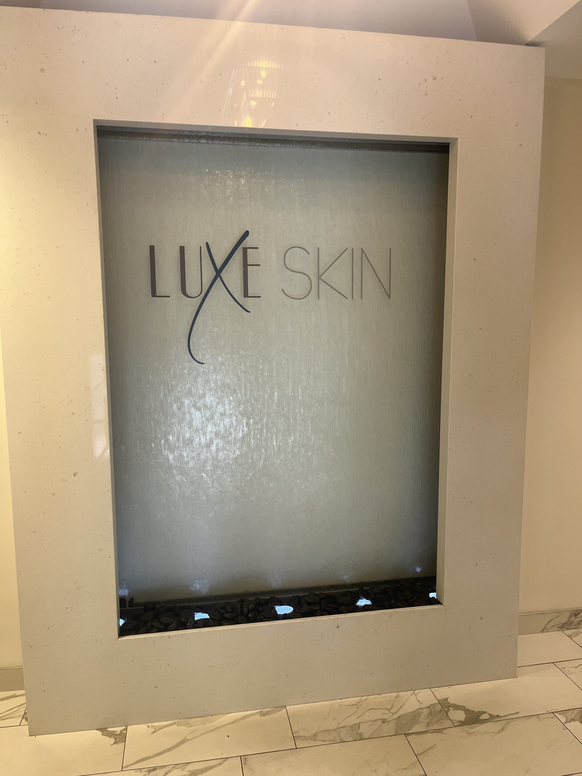 Frameless Glass Water Wall with Vinyl Logo at Luxe Skin Medical Spa in Naperville, Illinois