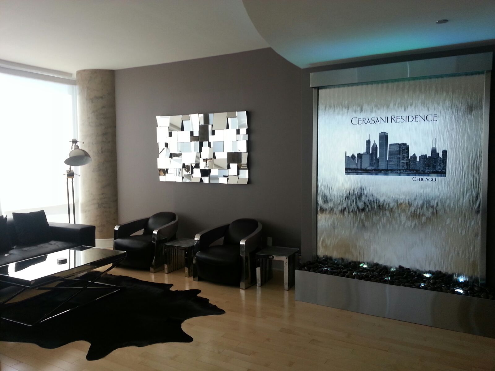 Mirror water wall waterfall featuring skyline design at Cerasani Residence in Chicago, enhancing modern interior aesthetics with a sleek black and silver decor.
