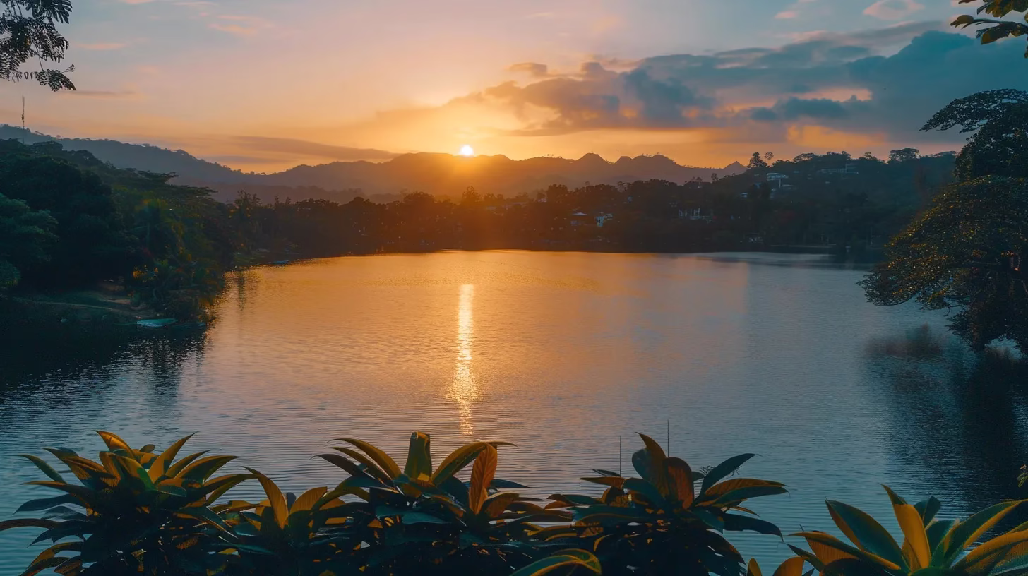 a breathtaking sunset casts a warm golden light over a tranquil lake, reflecting vibrant hues of orange and pink on the water's surface while lush trees frame the serene landscape.